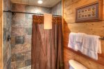 Walk-in shower with natural stone tile